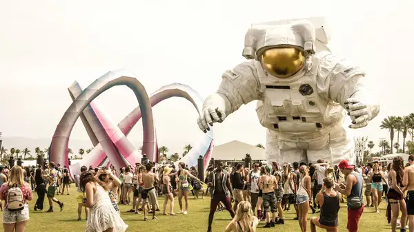 Boneco astronauta flutuando sobre pessoas durante Coachella