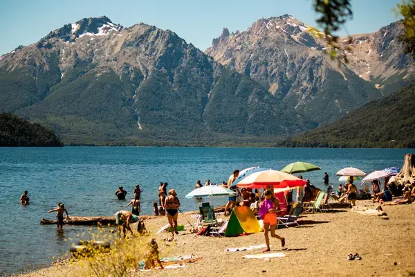 Pessoas tomando banho em lago durante verão em Bariloche