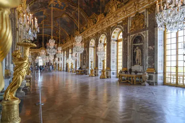sala de edifício com espelhos e muros em brando e dourado