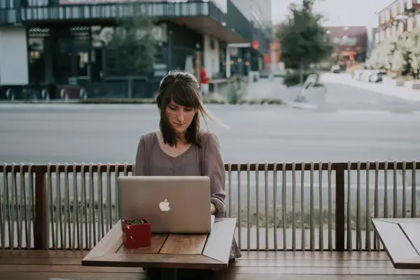 mulher trabalhando em notebook em mesa na rua