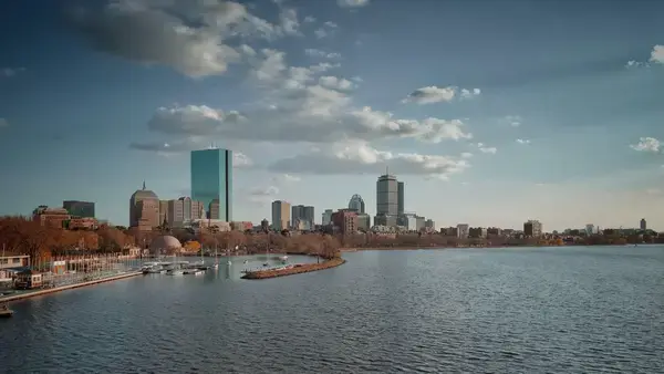 horizonte da cidade de Boston refletido no corpo da água e céu nublado