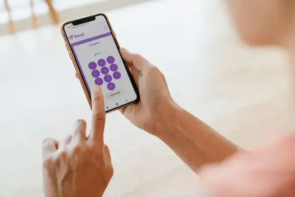 Mulher utilizando o aplicativo da Real Seguro Viagem