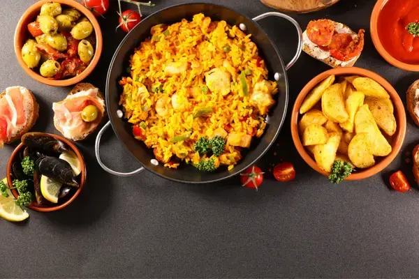 mesa posta com pratos recheados de comida colorida