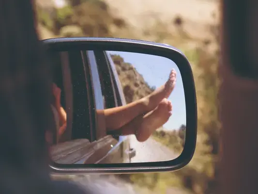 Pés femininos em janela de carro