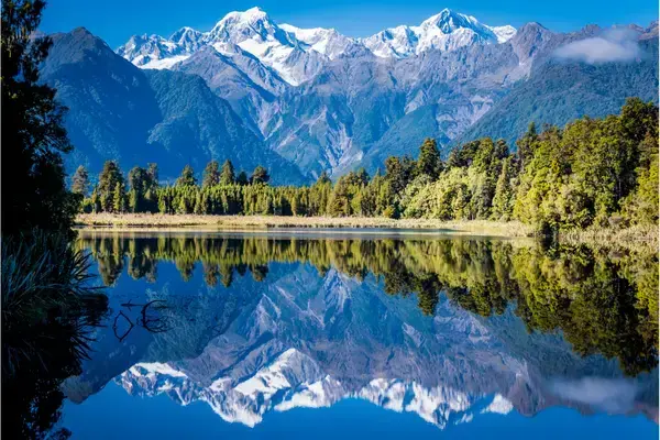 Montanha refletida em rio da Nova Zelândia