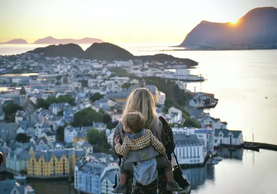 Mãe com bebê nas costas observando paisagem