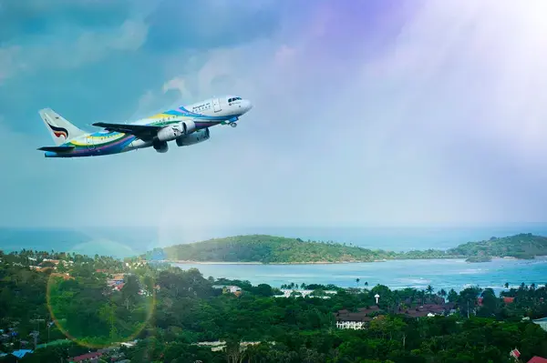 um avião decolando, ao fundo uma paisagem paradisíaca do mar e natureza