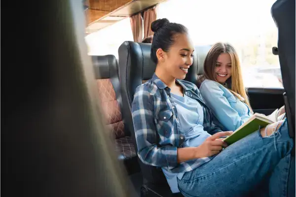 Mulheres em ônibus rindo juntas