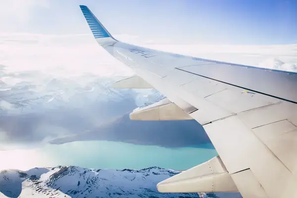 Vista de asa de avião sobrevoando a neve