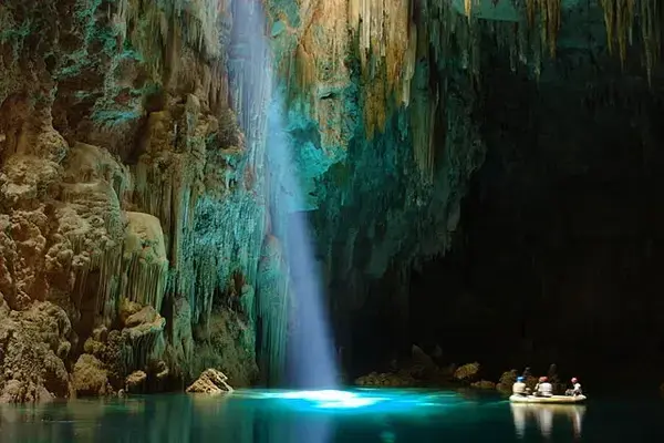 Interior do abismo Anhumas iluminado por raios solares através de claraboia natural.