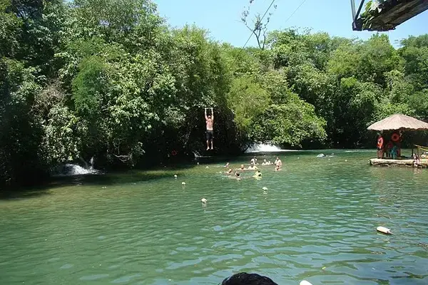 pessoas em grupo dentro do rio com tom verde esmeralda
