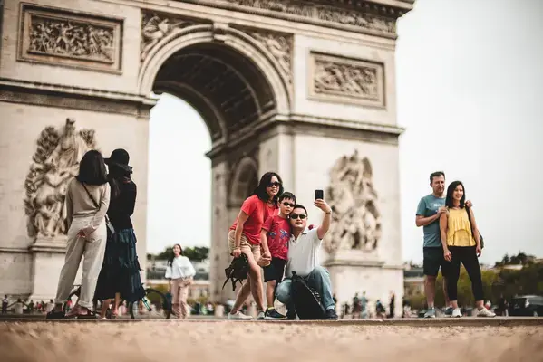 Família tirando foto em frente ao Arco do Triunfo, em Paris