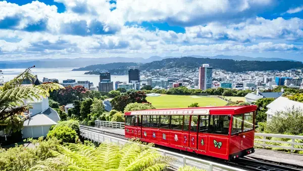 trem vermelho passando pelo edifício a luz do dia