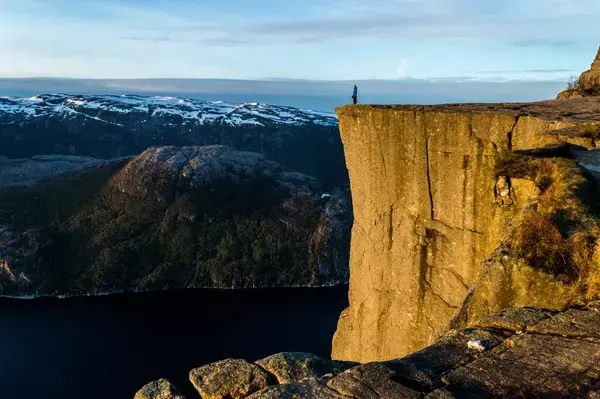Pessoa em frente ao precipício em Preikestolen, Noruega