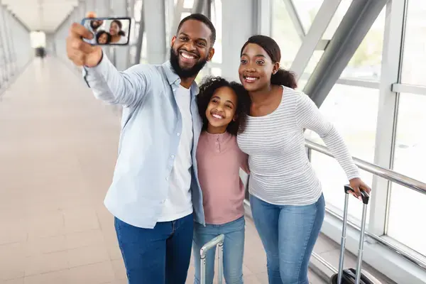 Família tirando foto com celular em aeroporto