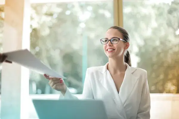mulher-de-negocios-positiva-cuidando-da-papelada-no-escritorio
