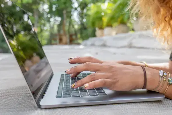 Mãos de mulher digitando em um notebook
