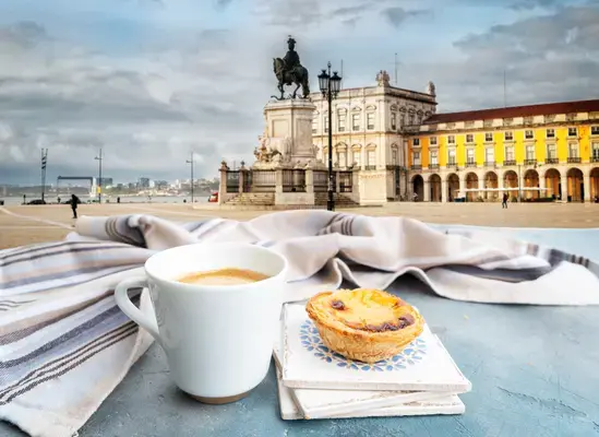 fotografia de um pastelzinho de belém acompanhado de um café na vista de lisboa com um lindo por do sol