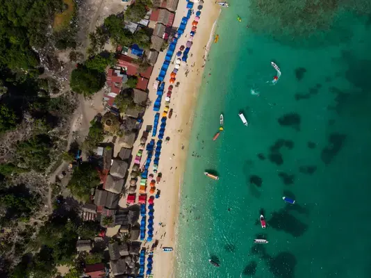 vista aérea da praia, areia e barcos no mar