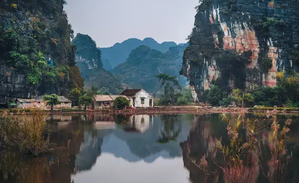 casa branca no meio de dois penhasco e uma lagoa na vista