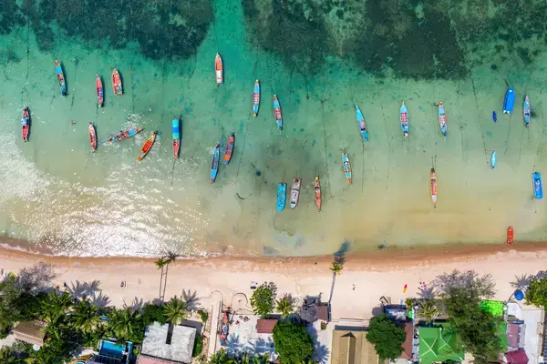 vista aérea da orla do mar com pranchas coloridas na faixa de areia