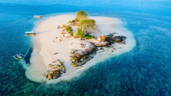 fotografia aérea da orla da praia cercada de arvores e ilhas