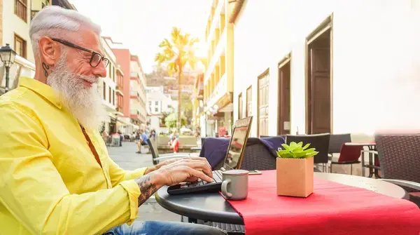 homem sentado na cafeteria em frente ao seu computador