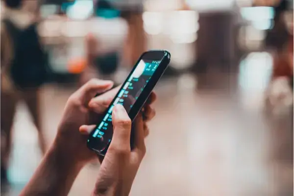 Mão segurando e navegando na internet pelo celular