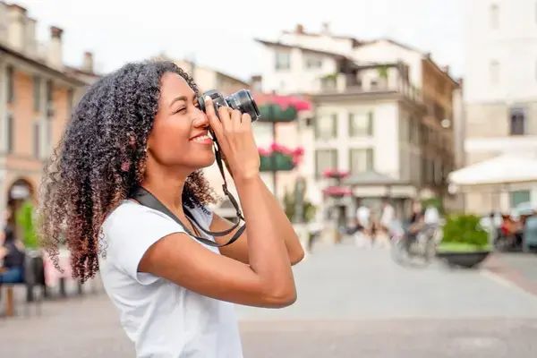 mulher com câmera fotográfica elevada aos olhos para capturar uma imagem