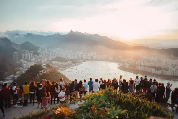 Pessoas em morro vendo a praia no Rio de Janeiro (Fonte: Unsplash)