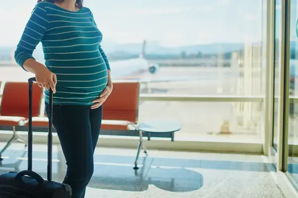 Mulher gestante em aeroporto (Fonte: Adobe Stock)