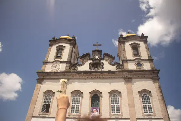 Mão segurando rosa branca em frente a Basílica do Senhor do Bonfim em Salvador, Bahia Fonte: Arquivo Pessoal