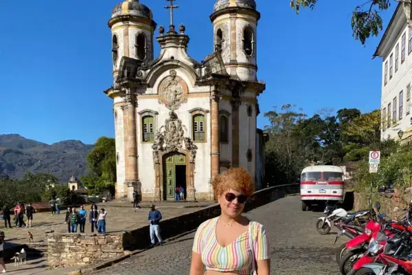 moça de óculos em frente a igreja antiga na cidade histórica