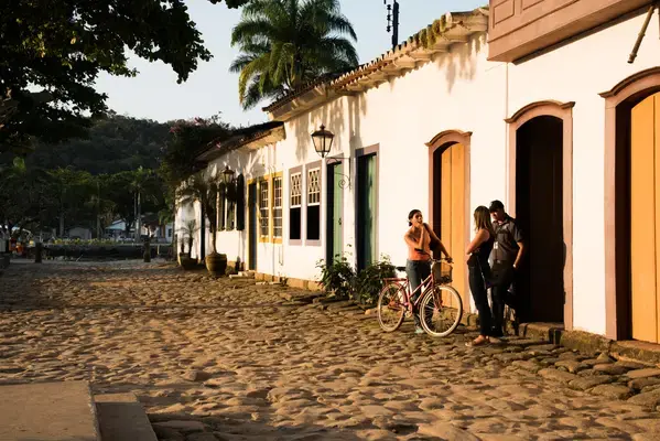 Pessoas conversando em frente a casa antiga em Paraty, Rio de Janeiro Fonte: Unsplash