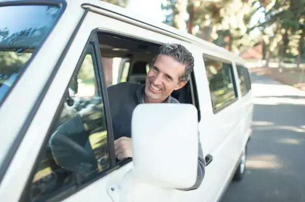 homem de suéter sorrindo pela camera