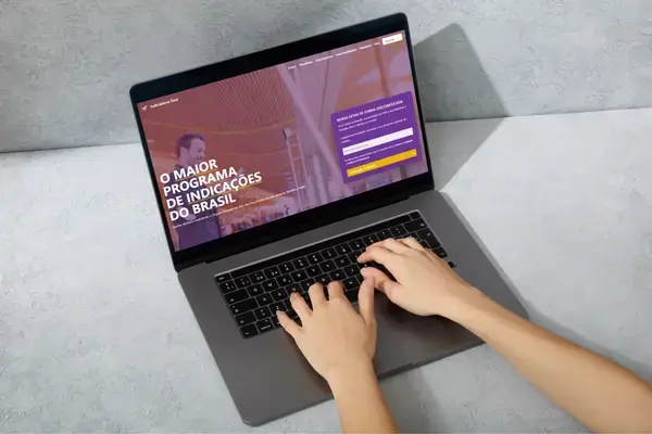 Pessoa usando notebook no programa de Indicadores da Real Seguro Viagem