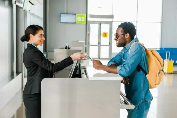 Homem em guichê de companhia aérea em aeroporto Fonte: Adobe Stock
