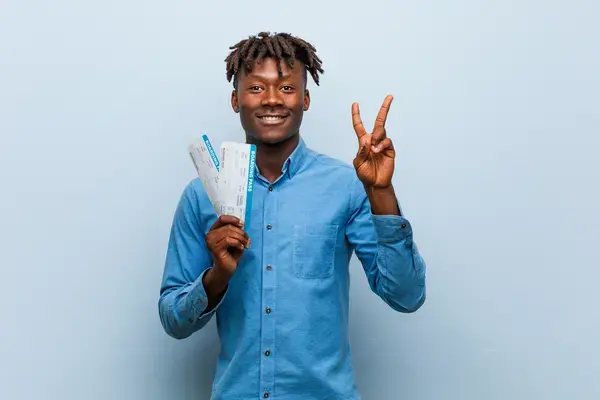 Homem feliz segurando passagem aérea Fonte: Adobe Stock