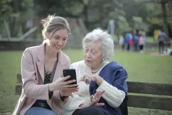 mae-senior-alegre-e-filha-adulta-usando-smartphone-juntas