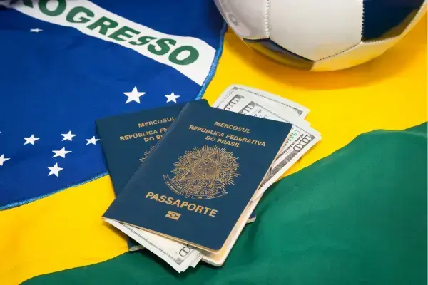 passaporte brasiliero e ao fundo a bandeira do Brasil