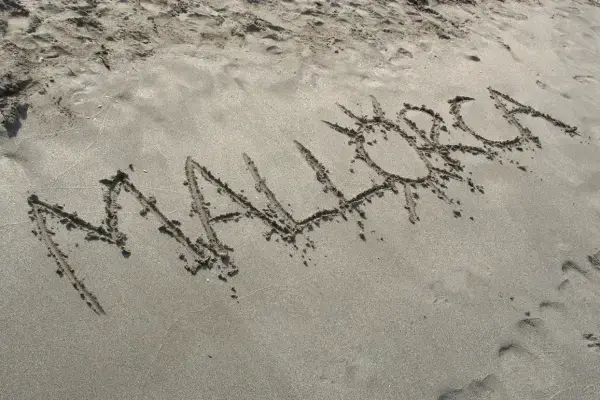 Escrita da palavra Mallorca em areia de praia