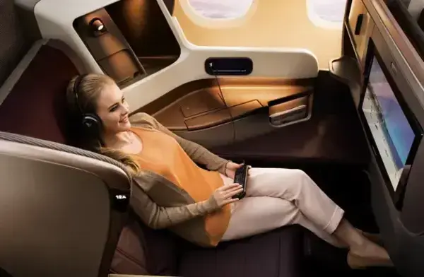 Mulher sentada em poltrona de classe executiva da Singapore Airlines (Fonte: Singapore Airlines/Reprodução)