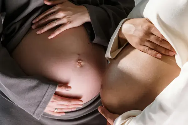 duas mulheres grávidas mostrando a barriga