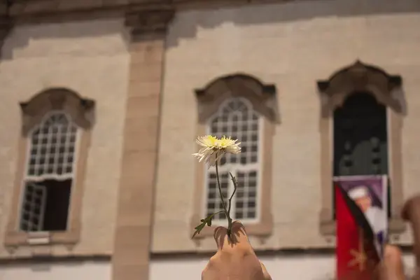 Mão segurando flor em frente a Basílica do Senhor do Bonfim em Salvador (Fonte: Arquivo Pessoal)