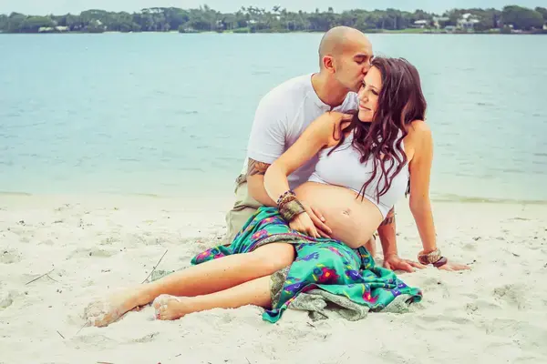 casal grávidos na areia da praia