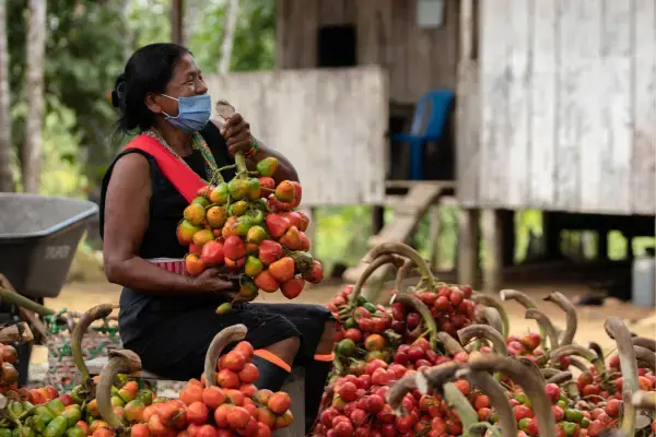 mulher sorrindo com um cacho de frutas nas mãos