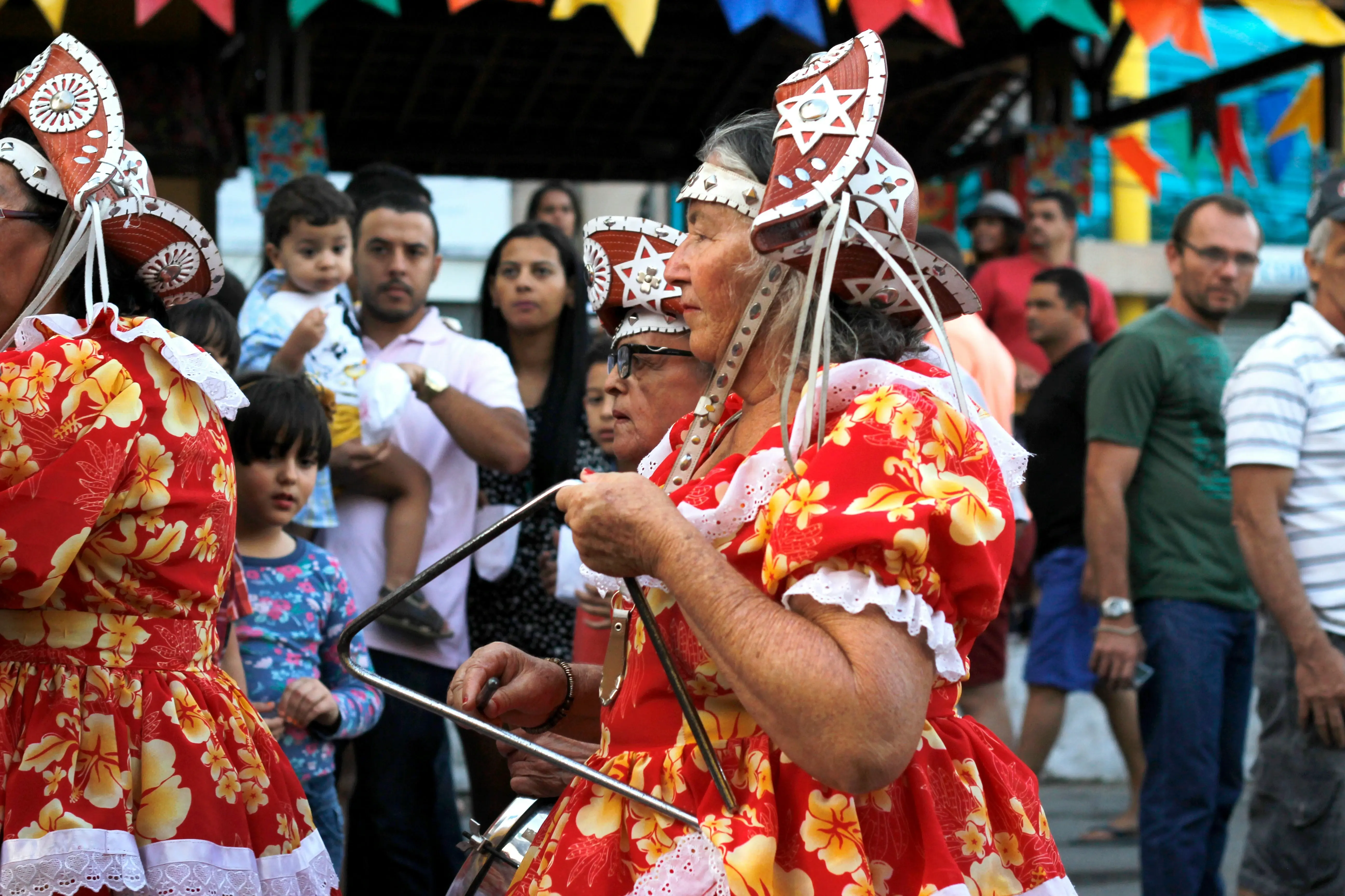 Mulher tocando triângulo em festa de São João em Caruaru (Fonte: Unsplash)