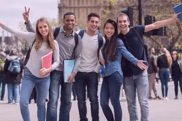 grupo de pessoas diversas com livros na mão e sorrindo