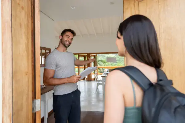 um homem recebendo uma pessoa em sua casa