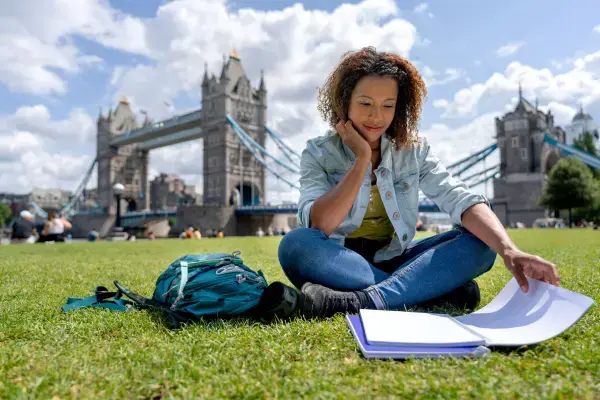 mulher estudando em frente a ponte (Fonte: Canva)